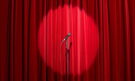 Microphone in spots light on empty stage with red curtain behind Success At Work, Standup Comedy, Stage Curtains, Drop Cloth Curtains, About Success, Women In Leadership, Cool Curtains, Red Curtains, How To Make Curtains