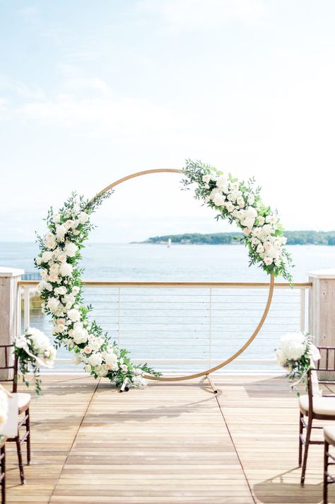 Circle arbor with white flowers for outdoor Beauport Hotel wedding on the water in Gloucester, MA. Photography by Sarah Surette. Wedding Arbour White Flowers, White Flower Wedding Decoration, Circle Arbor Wedding Flowers, Circular Arbor Wedding, Circle Arch Wedding Flowers, Circle Alter Wedding, Round Wedding Arbor, Circle Arbor Wedding, Circle Arch With Flowers