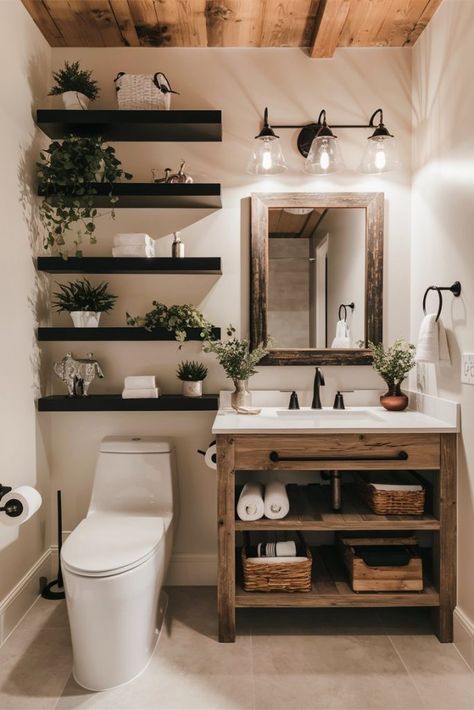 A modern bathroom featuring white subway tile walls, black fixtures, and a rustic wood vanity with open shelving. The vanity is topped with a white countertop and a rectangular mirror with a wooden frame. Three black pendant lights hang above the mirror. To the left of the vanity, there are black floating shelves adorned with various green plants. Above the toilet, there are more floating shelves with bathroom decor and plants. The bathroom includes a white toilet and light gray floor tiles. Ensuite Decor Ideas, Wood White And Black Bathroom, Black And Wood Interior Design Modern, Natural Wood And Black Bathroom, Bathroom Wood And Black, Restroom Inspo Aesthetic, Green Decor Bathroom Ideas, Black White And Natural Wood Bathroom, Above Toilet Shelving