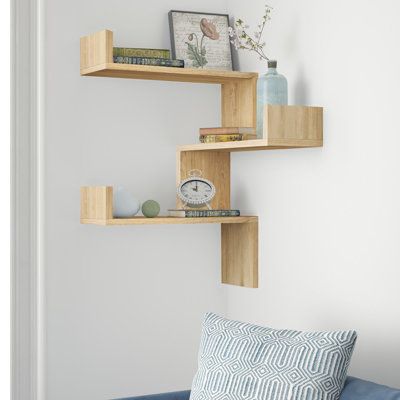 This 3-piece set of geometric shelves brings unconventional storage with a modern look to your living room or bedroom. Crafted from engineered wood with a solid hue finish, these three shelves feature L-shaped silhouettes that rest together and are meant to be installed in a corner. We love how the pieces interlock once installed to form a unique, dynamic effect, while still offering plenty of room for your trophies, keepsakes, and souvenirs. Each shelf measures 24'' long and supports up to 13 l Corner Shelves Wall Mounted, Bathroom Furniture Shelves, Wall Shelves Decor, Corner Shelf Unit, Geometric Bookcase, Wall Shelves Bedroom, Wall Shelf Unit, Geometric Shelves, Corner Wall Shelves