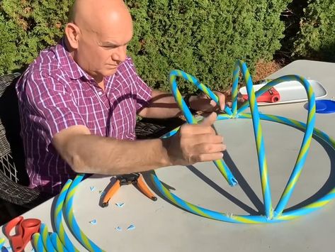 Man shows how to make giant Christmas ornament with mesh and hula hoops from Dollar Store Diy Christmas Yard Decorations, Giant Christmas Ornaments, Outdoor Christmas Decorations Yard, Large Christmas Ornaments, Christmas Yard Art, Outdoor Christmas Tree, Christmas Float Ideas, Dollar Store Christmas, Christmas Yard Decorations