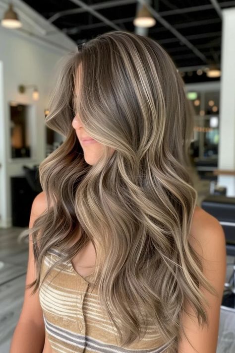 Woman with long, wavy hair featuring blonde highlights in a salon setting. Highlights With Dirty Blonde Hair, Dirty Blonde With Blonde Highlights, Caramel Highlights On Dirty Blonde Hair, Blonde With Brown Lowlights Caramel, Low Light And Highlights, Sandy Blonde Balayage Brown Hair, Dirty Blonde Hair With Lowlights Dark, Blonde Highlights For Dark Brown Hair, Dirty Blonde Hair With Highlights And Lowlights