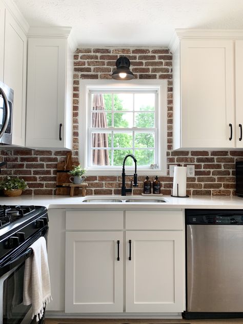 Red Brick Backsplash Kitchen White Cabinets, White Kitchen With Red Brick Backsplash, White Kitchen Cabinets Black Countertops Brick Backsplash, Red Brick Kitchen Backsplash, Decor Behind Stove, White Cabinets Brick Backsplash, Red Brick Backsplash Kitchen, White Shaker Cabinets Black Hardware, Farmhouse Kitchen Brick Backsplash