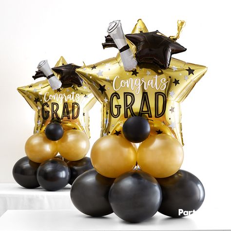 Create centerpieces that shine as bright as they do! The black, silver and gold color scheme is a graduation classic. Make it your own by DIY-ing a few stacked balloon centerpieces. First, create the black and gold base with nine latex balloons. Then, secure your 3D star balloon topper to the base you just created and fill the empty spaces with coils of curling ribbon for a finished look. There's no better way to say, "Congrats Grad!" than with decorations that say it for you! Graduation Centerpieces, Graduation Party Desserts, Balloon Centerpiece, Senior Graduation Party, Graduation Tables, Graduation Party Centerpieces, Diy Graduation, Graduation Party Themes, Graduation Party Planning