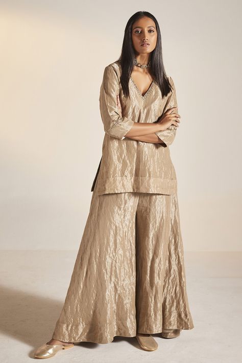 Champagne grey kurta in handloom tissue fabric base and embroidered neckline. Paired with tiered sharara. Component: 2 Pattern: Embroidery Neckline: V neck Sleeve Type: Three quarter Fabric: Handloom Tissue Color: Grey Other Details:  Approximate Product Weight (in kg): 1 Embroidered neckline Tiered sharara Note: Dupatta worn by the model is not for sale Outfit worn by the model on right is not for sale Since all our products are sustainable and touched by human hands for weaving, block printing Kurta And Sharara Set, Kurta And Sharara, Gold Suit, Indian Dresses Traditional, Traditional Indian Outfits, Kurti Designs Party Wear, Designer Dresses Casual, Designer Party Wear Dresses, Stylish Party Dresses