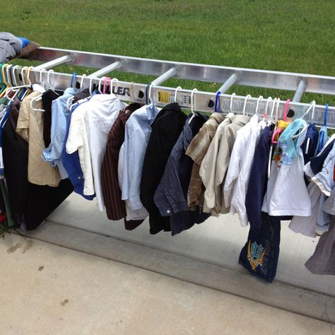 Great idea for displaying clothes at a garage sale! Turn a ladder horizontally and lay each side on a table and hang clothes from both sides! Yard Sale Display Clothes, Clothes Rack For Garage Sale, Garage Sale Clothes, Yard Sale Clothes, Yard Sale Clothes Rack, Yard Sale Display, Yard Sale Hacks, Garage Sale Organization, Yard Sale Organization