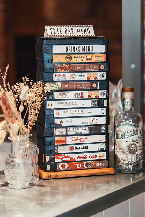 Unique wedding bar drinks menu sign made from old VHS tapes | Suzy Elizabeth Photography Wedding Ideas Movie Theme, Film Themed Wedding, London Theme Wedding, Movie Wedding Aesthetic, Cinema Wedding Theme, Wedding Movie Theme, Vintage Theme Wedding Decor, Movie Wedding Theme, Film Theme Wedding