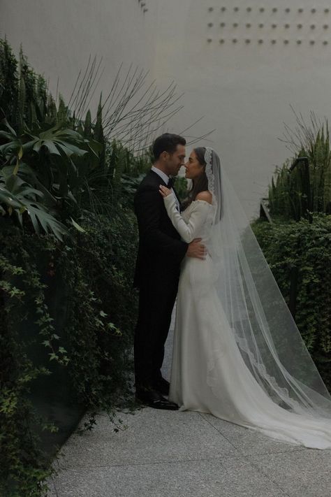 Bride wears a classic off the shoulder gown with a scalloped cathedral length veil, looking up at her groom, wearing a black tuxedo Simple Wedding Dress With Veil Lace, Mexican Bridal Veil, Mantilla Veil Hair Down, Super Long Veil Wedding, Sheath Wedding Dress With Veil, Wedding Veils Covering Face, Spanish Style Wedding Dress Spain, Italian Bride Traditional, Spanish Style Veil