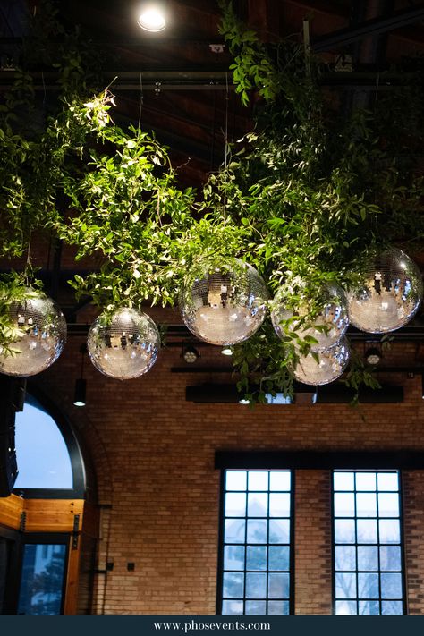 Retro meets elegance with this greenery hanging instillation featuring our fun and sparkly disco balls! To see more from our lighting inventory and weddings we've been part of, click the link in the pin and check out our website.   wedding lighting | wedding reception | elegant wedding | Minnesota wedding | wedding trends 2024 | wedding disco balls Greenery With Disco Balls, Greenery Wedding Reception, Athol Hall, Wedding Reception Elegant, Disco Ball Wedding, Wedding Trends 2024, Wedding Disco, Lighting Wedding, Wedding Retro