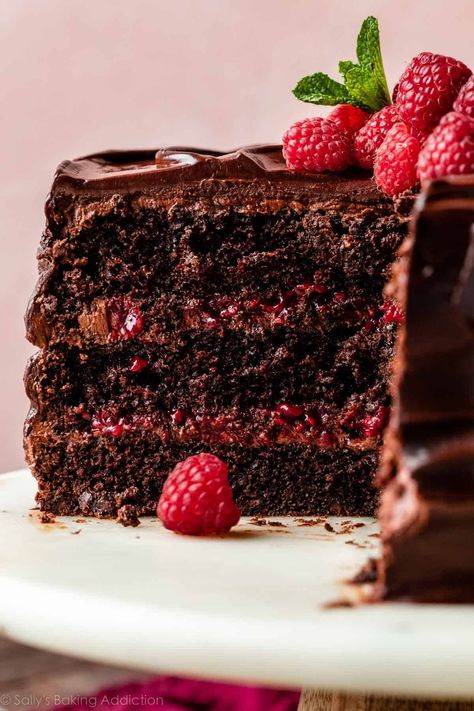 There's so much to love about this ultra-rich chocolate raspberry cake. Layers of moist dark chocolate sponge, silky chocolate buttercream, and homemade raspberry filling are enrobed in a luxurious chocolate raspberry ganache. This is a decadent dessert for anyone who loves the flavor combination of raspberries paired with deep, dark chocolate. Recipe on sallysbakingaddiction.com Different Chocolate Cake Flavors, Rich Dark Chocolate Cake, Chocolate Raspberry Filling, Dark Chocolate And Raspberry Desserts, Chocolate Layer Cake Filling Ideas, Chocolate Raspberry Layer Cake, Dark Chocolate Raspberry Cake, Chocolate Raspberry Dessert Recipes, Chocolate Raspberry Birthday Cake