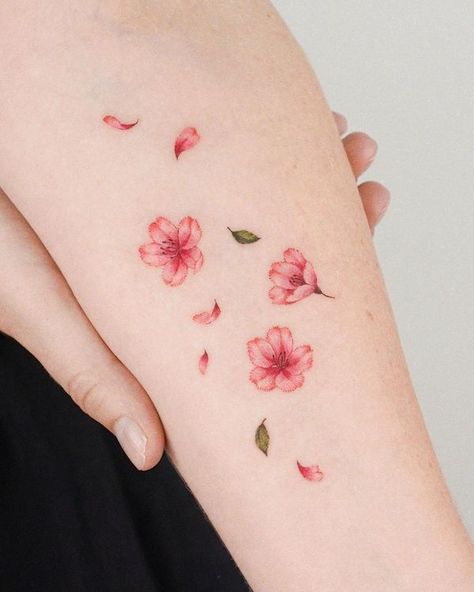 Sakura Petal Tattoo, Sakura Small Tattoo, Cherry Blossom Falling Petals Tattoo, Japan Minimalist Tattoo, Pink Daffodil Tattoo, Falling Cherry Blossom Tattoo, Pink And Green Tattoo, Cherry Flowers Tattoo, Sakura Arm Tattoo