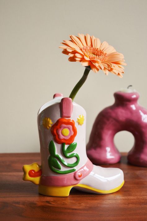 Cowgirl Giddy Up Vase Check more at https://howcandothis.com/diyideas/cowgirl-giddy-up-vase/ Small Ceramic Projects, Air Dry Clay Vase, Cowboy Boot Vase, Arcilla Ideas, Kitsch Design, Funky Vases, Quirky Vases, Boot Vase, Pottery Inspo