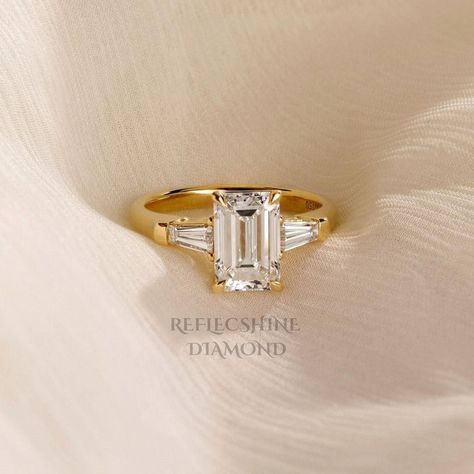 Free Shipping Main Stone: 2.50 Carat Side Stones: 0.25 Carats Total carat weight: 2.75 Carats Gold metal: 14k Yellow Gold Diamond Shape: Emerald cut Clarity: VVS2  Color: E Comments: Lab Grown Cut: Excellent All products comes with International Gemologist Certificates. Please feel free to contact me for any questions or details , gold upgrades, diamond upgrades etc' 30-Day Returns 100% Full Refund We are fully behind every diamond and piece of jewelry that we sell. It is vital for us that you a Emerald Cut Tapered Baguettes, Classic Winston Emerald-cut Engagement Ring With Tapered Baguette Side Stones, Emerald Baguette Engagement Ring, Three Stone Gold Engagement Ring, Three Stone Emerald Cut Engagement Ring, Emerald Cut With Baguettes, Gold Engagement Ring Emerald Cut, Rectangle Engagement Rings, Square Engagement Rings