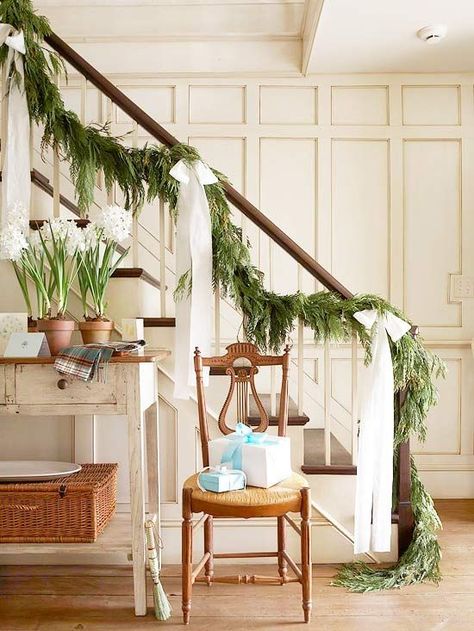 Graceful Christmas bows with long tails dramatically enhance a simple evergreen garland. To achieve this look cut extra-long strips of wide ribbon or fabric, tie into bows, and attach to the stair railing about 3 feet apart. This Christmas garland look is that easy! #holidaydecorating #christmasdecorideas #garlandideas #holidaygarland #garlanddecor #bhg Stair Bannister, Christmas Banister, Christmas Stairs Decorations, Christmas Stairs, Christmas Staircase, Christmas Tablescape, Stair Decor, Holiday Garlands, Garland Decor