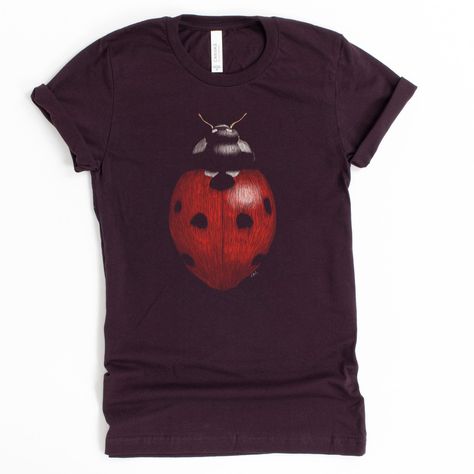 Did you know that one ladybug can eat up to 5,000 insects in its lifetime? Luckily, this shirt doesn't eat insects, or anything at all! Show your love for these cute beetles without the worry of losing it in the house. -------------- Every item sold plants 1 tree- Eco-Friendly shirts-------------- 100% combed and ring-spun cotton (heather colors contain polyester)- Soft, stretchy material--not heavy or rigid- Fabric weight: 4.2 oz (142 g/m2)- Shoulder-to-shoulder taping- Side-seamed------------- Pretty T Shirts, Bug Aesthetic Outfit, Insect Outfit, Ladybug Clothes, Indie Shirts, Bug Clothes, Ladybug Shirt, Shirts To Buy, Weird Clothes