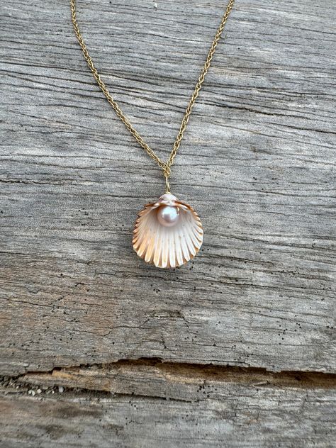 I regularly walk on the beach on the hunt for special nature treasures - shells, seaglass, ceramics and more. Craft supplies abound! I found this tiny lovely pearl and it was absolutely perfect and completely intact.  It paired beautifully with a high quality pink pearl and a delicate chain. I drilled the shell and wrapped the pearl with gold filled wire.  The perfect souvenir and a reminder of the days spent on the beach! Homemade Shell Necklace, Wire Wrapped Shell Jewelry, Shell Necklace Aesthetic, Seashell Necklace Diy, Shell Necklace Diy, Shell Locket, Beach Rings, Sea Shell Necklace, Shell Jewellery