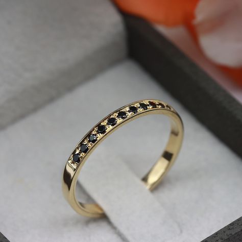 This exquisite half eternity ring features 11 stunning black onyx gemstones set in a beautifully crafted band. The timeless design of this ring showcases the deep, lustrous hue of each gemstone, creating a striking contrast against the high-polish finish of the metal. The black onyx stones, which are believed to provide protection and strength to the wearer, are elegantly arranged in a row along the top half of the ring, creating an alluring and sophisticated look. Crafted from high-quality mate Black And Gold Wedding Ring For Women, Black Gemstone Ring, Rings Black, Silver Stacking Rings, Black Onyx Stone, Peridot Gemstone, Black Jewelry, Onyx Ring, December Birthstone