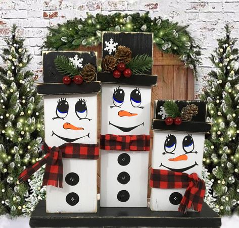 "My whimsical winter snowman family is sure to brighten your holiday. Display on your mantel, table or place on the floor by your Christmas tree. They might be smiling or singing a Christmas carol. This trio of snowmen measure 13\" wide x 13-1/4\" tall x 3-1/2\" deep. The center man snowman measures 12-1/4\" tall The woman snowman measures 10-3/4\" tall. The child snowman measures 7-3/4\" tall. The base and snowmen are made of wood. They are all hand painted with acrylic paint. I attached the hat brim with E6000 glue to make sure it stays put and made sure to tilt them a little for a more whimsical look.  I hot glued the ornaments on the hats. I hand painted the faces and buttons. I love the little carrot noses. The scarfs and bow tie are made of fabric and attached with hot glue. I also f Diy Snowman Wood Craft Ideas, Wooden Crafts For Christmas, Wooden Crafts Christmas, 4 X 4 Christmas Crafts, Snow Man Christmas Decor, Snowman Wooden Crafts, Snowman Wood Crafts Diy, Pallet Wood Snowman, Snowmen Wood Crafts