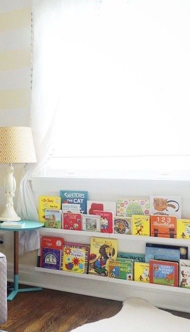 Under Window Nursery Storage, Book Storage Under Window, Nursery Bookshelves Wall Shelves, Books Under Window Nursery, Nursery Mirror And Shelves, Wall Mounted Bookshelves Nursery, Toddler Room Book Storage, Book Shelf Under Window, Under Window Toy Storage