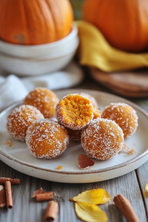 Pumpkin spice truffles coated in sugar, with a bite taken out of one, on a rustic wooden table. Pumpkin Spice Energy Balls, Pumpkin Spice Balls, Pumpkin Pie Balls, Pumpkin Energy Bites, Pumpkin Energy Balls, Healthy Pumpkin Cheesecake, Coconut Energy Balls, Pumpkin Balls, Frozen Pumpkin