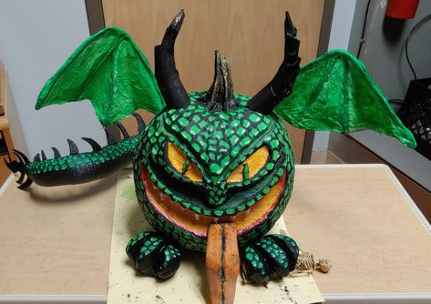 Dragon Pumpkin. Carved and painted pumpkin body, russet potato feet, and sweet potato tongue.  Carved and painted pool noodle tail.  Card board horns and tail tip.  Wire, tissue paper and modge podge wings Dragon Pumpkin Decorating, Dragon Pumpkin Painting, Pumpkin Carving Alternatives, Pumpkin Dragon, Dragon Pumpkin, Devil Pumpkin, Zombie Pumpkin, Witch Fingers, Pumpkin Carved