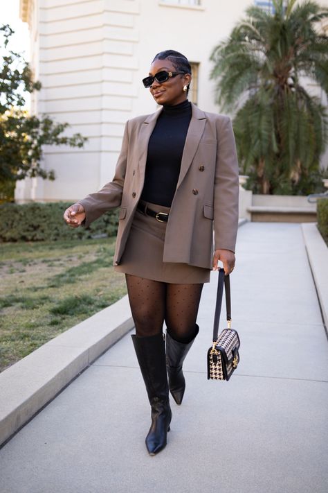 Black women with a short pixie cut wearing a taupe colored mini skirt suit with sheer tights, black knee high boots, houndstooth purse and black sunglasses Skirt Suit Black Women, Women Suit With Skirt, Female Skirt Suits, Debate Outfits, Skirt Suit Outfit, Grad Suits, Winter Mini Skirt, Style A Skirt, Graduation Fits