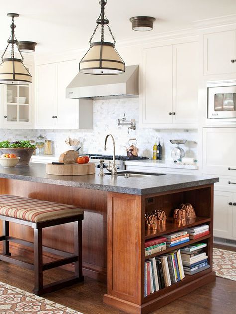 The island and cabinets in this kitchen share a clean and simple style. The dark wood of the island pops against the creamy white backdrop. Contrasting Kitchen Island, Kitchen With An Island, Cookbook Shelf, Kitchen Island Bench, Wood Island, Diy Backsplash, Kitchen Remodel Idea, Küchen Design, Kitchen Style