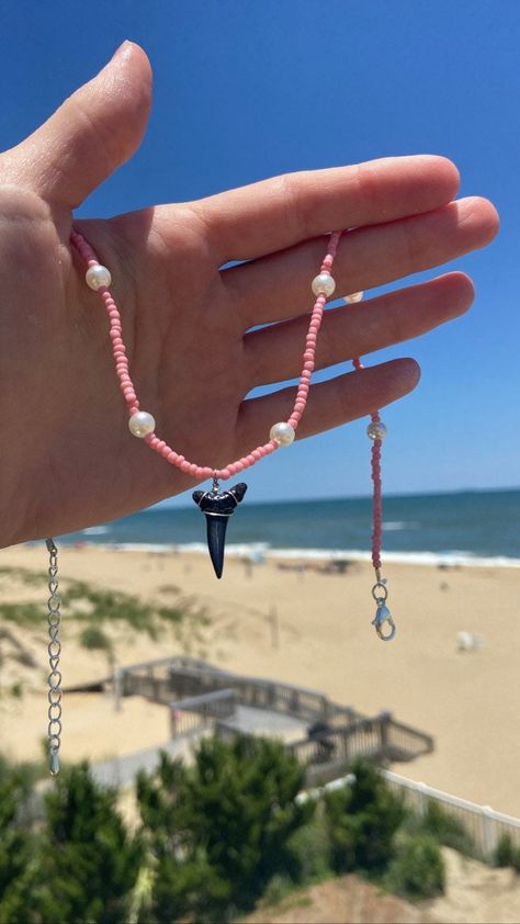 This is the  wonderful Pink Tooth necklace. The pink glass beads and faux pearls help this necklace beautiful. The fossilized shark tooth at the center ties the necklace together giving it natural yet fashionable look. Shark teeth have been worn by first humans to walk this earth. Shark teeth are said to give protection and safety while wearing them. Do yourself a favor and get your very own piece of paradise! Every necklace is handmade with love and care🤍 How To Make Shark Tooth Necklace, Beaded Shark Tooth Necklace, Shark Tooth Necklace Aesthetic, Shark Teeth Crafts, Tiktok Jewelry, Shark Teeth Jewelry, Pink Beaded Necklace, Beachy Necklace, Beachy Jewelry