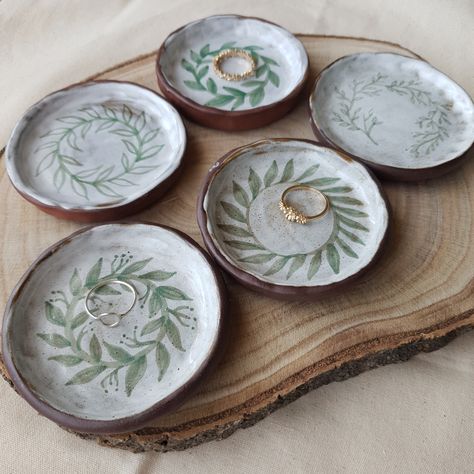 Handmade ceramic ring dishes, made from a red/brown stoneware ceramic clay, glazed white on top and then handpainted with green botanical designs.  This listing is for ONE ring dish - please choose the one you want.  Perfect for keeping your rings or other small pieces of jewellery safe and organised on your bedside table. Ceramic Ring Dish Handmade, Small Ceramic Ideas, Small Pottery Ideas, Ceramic Ideas Pottery, Trinket Dish Clay, Pottery Ring, Ceramic Jewelry Dish, Clay Products, Ceramics Pottery Vase