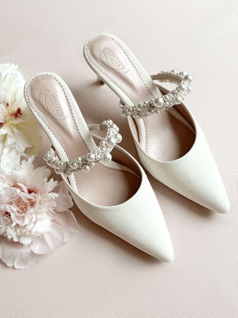 Introducing 'Honor Pearl', our new stylish mule wedding shoe with an elegant stiletto kitten heel. Handmade using the very best Italian suede and leather, with hand sewn embellishments. The super soft kid suede will soften around your feet keeping you secure and comfortable on your wedding day. The embellished leather elasticated strap will keep your foot secure, ensuring maximum all day comfort with a touch of sparkle! Our embellished styles are hand-beaded to order. Please expect delivery within 4-6 weeks. If your wear date is sooner, please contact us at onlineboutique@emmylondon.com. Bridal Shoes Green, Low Heels Wedding, Blue Bridal Shoes, Bridal Shoes Low Heel, Ivory Bridal Shoes, Pink Wedding Shoes, Wedding Shoes Low Heel, London Logo, Ivory Wedding Shoes