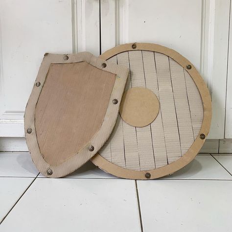 Diy Shield Cardboard, Cardboard Shield Diy, Knight Shield Diy, Diy Viking Ship Cardboard, Cardboard Props Cosplay, Cardboard Armor Diy Templates, Cardboard Helmet Diy, Roman Shield Craft For Kids, Cardboard Knight Costume