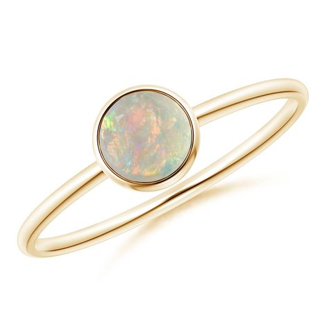 Simple yet elegant, this classic solitaire opal ring is sure to fascinate. The cabochon opal, secured in a bezel setting, allures with its delightful color play. This 14k yellow gold round opal ring has a sleek shank that adds to its effortless beauty. Solitaire Opal Ring, Opal Stone Ring, Opal Solitaire Ring, Effortless Beauty, Color Play, Contemporary Ring, Opal Stone, Stackable Ring, Opal Ring