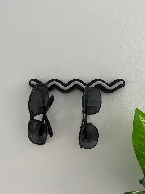 Keep your sunglasses organized and within reach with our stylish 3D Printed Wall Mount Sunglasses Holder! This sleek and modern design is perfect for displaying your favorite pairs while saving space. Available in a variety of vibrant colors, you can choose the perfect match for your décor. Made from durable, high-quality materials, this holder is easy to install and adds a touch of convenience to any room. Elevate your accessory game with this must-have organizer! Choose from many colors to cus Hat And Sunglasses Rack, Sunglasses Holder Wall, Diy Sunglasses Organizer, Sunglass Holder Diy, Sunglasses Organization, Office Cubical Decor, Sunglass Rack, First Home Checklist, Sunglasses Wall