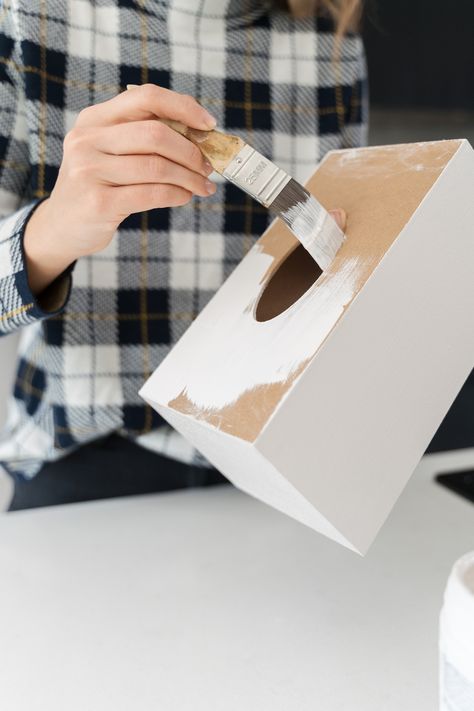 Looking for an inexpensive stylish tissue box idea? Look no further than this plain craft tissue box design using Mod Podge and tissue paper! You only need six materials to make this easy tissue box cover! Here you see Gina from Style Curator using white paint on the tissue box to create a good base. To find the full tissue box DIY, click on the pin! Wood Kleenex Box Cover, How To Make Tissue Box Diy, How To Make A Tissue Box Cover, Tissue Box Decoration Ideas, Tissue Paper Box Diy, Painted Tissue Box Covers, Diy Kleenex Box Cover, Tissue Box Covers Diy, Diy Tissue Box Holder