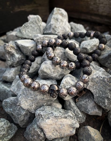 Introducing our Lava Rock & Skull Stretch Bracelet, a bold and versatile piece designed for both men and women. This unisex bracelet features authentic electroplated lava rock beads, known for their grounding and calming properties. Lava stones are believed to bring strength and stability during times of change, helping to dispel negativity and promote emotional balance. The bracelet is accented with sleek gunmetal-plated elements and brass cubic zirconia beads, adding a touch of shimmer and ele Bracelets Set, Emotional Balance, Beaded Skull, Lava Rock, Unisex Bracelets, Unisex Jewelry, Lava Stone, Dark Night, Black Stainless Steel