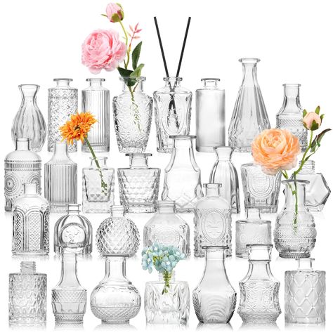 PRICES MAY VARY. STURDY AND THICK GLASS---30 pcs bulk bud vases are made of high quality thick and strong glass,which are durable and not easy to break. The bottom is non-slip and the center of gravity is stable. These petite little vases were perfect for wedding tables and also be reused for any other table decor or home decor. You can also add some dried flowers or aromatherapy sticks to the vase. ALL UNIQUE DESIGNS AND DIFFERENT SHAPES AND SIZES---The biggest feature of these 30 small bud vas Hiasan Perkahwinan, Vasos Vintage, Vases For Centerpieces, Wedding Table Decorations Centerpieces, Glass Vases Centerpieces, Vases For Flowers, Small Vases, Tafel Decor, Small Glass Vases