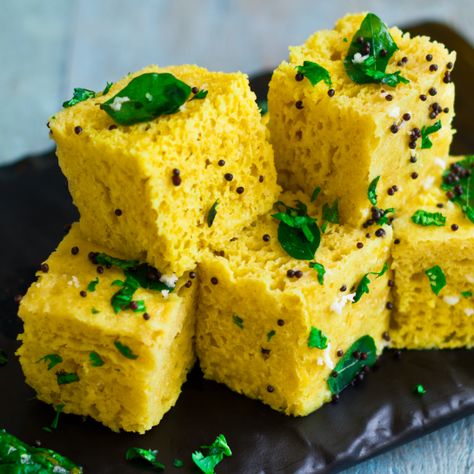 Dhokla is a nutritious Indian food with a base of fermented chickpea batter and rice. It originates from the Gujarat region, though its popularity has spread throughout India. #dhokla #tasty #snacks #indian #yummy #tasty #gujarati #gujarat Khaman Dhokla, Dhokla Recipe, Spicy Snacks Recipes, Breakfast Recipes Indian, Sweet Dishes Recipes, Vegetarian Snacks Recipes, Spicy Snacks, Indian Dessert Recipes, Gujarati Recipes