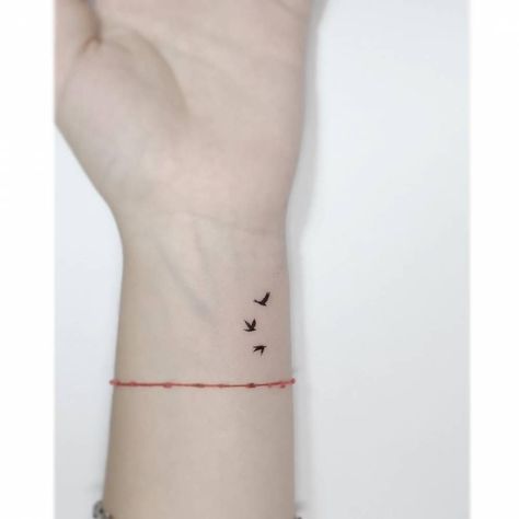 Minimalistic style flying birds tattooed on the wrist. Let It Be Tattoo With Birds, Three Small Birds Tattoo Simple, Small Bird Wrist Tattoos For Women, Birds On Wrist Tattoo, Three Flying Birds Tattoo, Minimalist Tattoo Freedom, 3 Birds Tattoo Wrist, Birds Flying Tattoo Arm, Tiny Sparrow Tattoos For Women