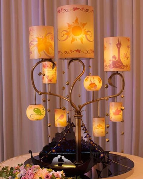 Happy Tangled Tuesday ☀️🌸 How beautiful is this Rapunzel lamp? And tower cake? And centerpieces?? 😂 I love it all ❤️ article and photos… Adult Disney Bedrooms, Tangled Centerpieces Diy, Rapenzul Wedding, Rapunzel Themed Centerpieces, Rapunzel Decorations Quince, Tangled Themed Graduation Party, Disney Wedding Table Decorations, Disney Wedding Themes, Quinceanera Rapunzel