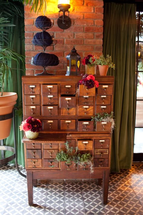 vintage library card catalogue used as escort card display.  some drawers are filled with fresh herb plantings while others have dahlia arrangements in coral, peach and burgundy. (photo courtesy of Kathi Littwin Photography - www.kathilittwin.com) Library Plants Aesthetic, Herb Drawer, Dahlia Arrangements, Apothecary Table, Apothecary Drawers, Vintage Library Card, Apothecary Chest, Library Card Catalog, Awesome Furniture