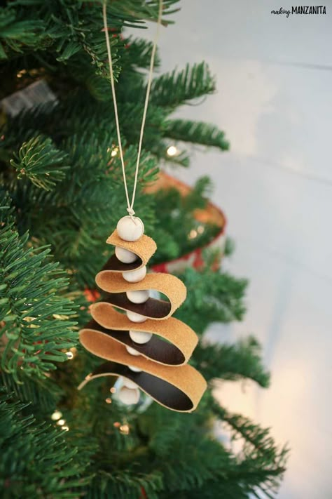 These DIY leather ornaments fit right in with the modern farmhouse home decor style and are such a great budget-friendly Christmas craft! This easy to follow tutorial will walk you through how to make this leather ornament that looks like a mini Christmas tree with wood beads. Diy Leather Ornaments, Leather Ornaments, Craft Ornaments, Boho Christmas Tree, Easy Christmas Ornaments, Easy Christmas Decorations, Leather Diy Crafts, Beaded Christmas Ornaments, Easy Christmas Diy