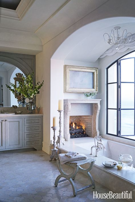 The arched window and the view from this California bathroom were so magnificent designer Ohara Davies-Gaetano didn't want to put a big white porcelain tub in front of it. Instead, she designed a sunken bath made from slabs of Crema Marfil marble. "Imagine lying in the bath with the flames flickering and the sun setting over the Pacific," she says. "What could be more relaxing?"   - HouseBeautiful.com Luxurious Bathrooms Master Baths, Sunken Bathtub, Sunken Tub, Decor Baie, Country Bathroom, Country Interior, Powder Rooms, Dream Bathrooms, Natural Home Decor