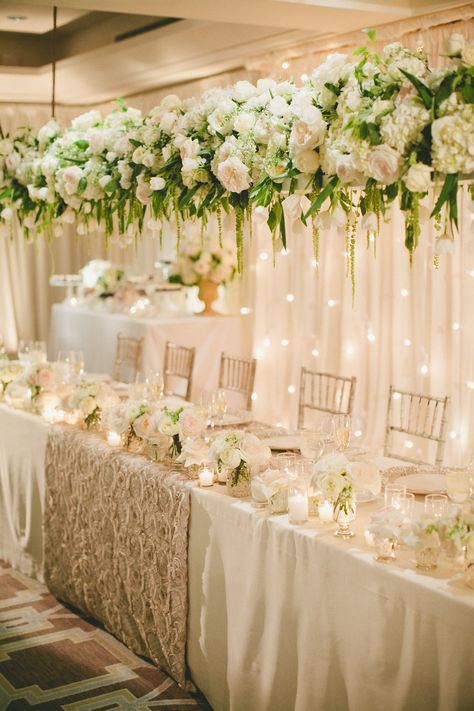 A longer view of the panel table. Gorgeous floral arrangement hanging above. Tablecloth Photography, Dreamy Tablescapes, Head Table Wedding Decorations, Floral Designs Arrangements, Head Table Decor, Table Flower Arrangements, Head Table Wedding, Floral Installation, Classic Wedding Decorations