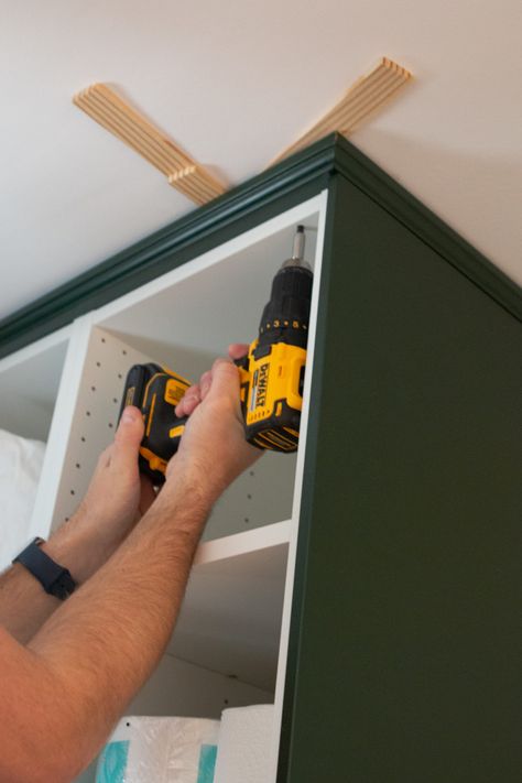 Adding crown molding to the ceiling. Come learn our tips for installing IKEA kitchen cabinets and making them look high-end and built-in. We used these dark green cabinets in our laundry room and they turned out absolutely gorgeous! #IKEA #ikeakitchen #DIYkitchencabinets Ikea Upper Cabinet, Crown Molding On Ikea Kitchen Cabinets, Ikea Kitchen Cabinet Hacks Built Ins, Ikea Crown Molding, Upper Cabinet Molding, Wall Kitchen Cabinets Ideas, Installing Ikea Kitchen Cabinets, Ikea Kitchen Crown Molding, Ikea Sektion Axstad Kitchen