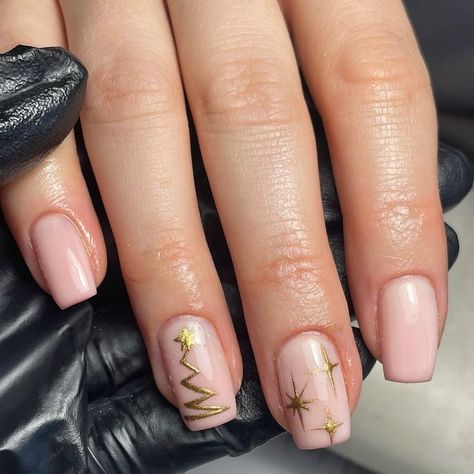 A chic and minimal design, these nude pink nails feature a delicate gold Christmas tree and star detailing, perfect for a subtle yet festive holiday look. The simplicity of the design gives it an elegant and modern appeal. Christmas Nails Gold, Simple Christmas Nails, Christmas Tree Nail Art, Star Nail Designs, Tree Nail Art, Christmas Nail Ideas, Christmas Tree Nails, Gold Nail Designs, Nude Nail Designs