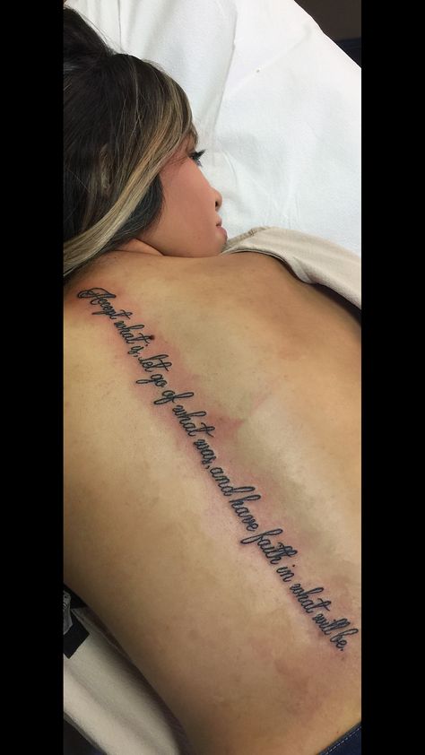 Spin Quote Tattoos, Song Lyric Tattoos Spine, Spine Tattoos Script, Spine Saying Tattoos For Women, Rare Spine Tattoos For Women, Bible Quote Spine Tattoo, Quote Down Spine Tattoo, Bible Spine Tattoo, Spine Tattoo Bible Verse