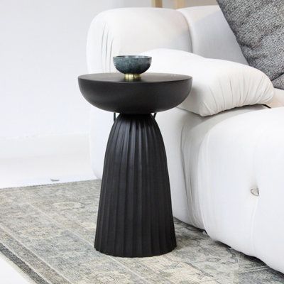 Infuse your living space with a touch of modern, liveable luxury with this minimal metal drum-shaped accent table. Constructed from casted aluminum, this curved sculptural piece is lightweight and functional without compromising style. Finished in a rich satin black with a ribbed pedestal base for a curved, modern organic look. Pair this strikingly unique side table with your favorite accent chair in the office or next to your living room couch for a one-of-a-kind conversation piece. | Cinched M Minimal Side Table, Egypt Sherrod, Unique End Tables, Black Accent Table, Foyer Furniture, Black Bedside, Unique Side Table, Pedestal Side Table, Living Room Couch