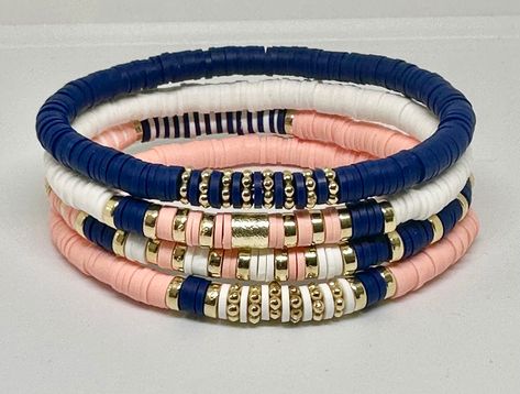 Set of 4 Navy, Light Coral, and White, hand beaded, stretch bracelets. Bracelets are made with 6mm Heishi beads with gold accents. Can customize with wording of your choice using white beads with gold letters. Blue Heishi Bracelet Ideas, Cute Heishi Bracelets Ideas, Heshi Bead Ideas, Bracelets Stacking, Bracelet Heishi, Stretch Beaded Bracelets Diy, Heishi Jewelry, Navy Bracelet, Womens Gifts