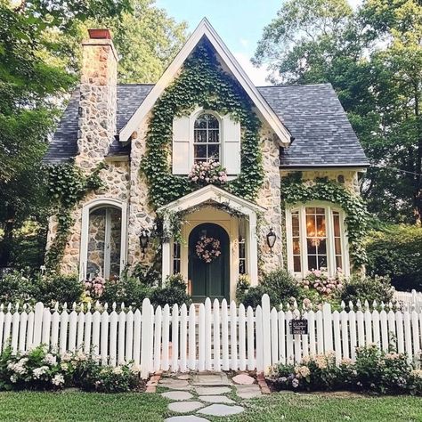 Cottagecore heart is full! 🏡💕 This dreamy abode with its white picket fence, floral accents, and stone chimney is pure magic. Bay windows, cozy porch, and ivy-covered walls create the coziest atmosphere. Pastel colors, vintage details, and a garden path leading to endless possibilities. #cottagecore #dreamhome #countryliving #homegoals #vintagevibes #gardenlife White Picket Fence House Dream Homes, Cottage With Lots Of Windows, Houses With Picket Fences, Front Yard Landscaping Victorian Home, Cottagecore Farmhouse Exterior, Dream Cottage Exterior, Houses With Vines, Vintage House Aesthetic Exterior, Old Vintage House Exterior