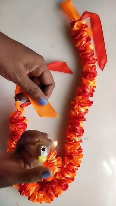 Hawaiian Lei Diy, How To Make Leis Tutorials, How To Make Ribbon Garland, How To Make A Lei, Graduation Lei Ideas, Diy Floral Garland, How To Make Leis, Flower Lei Diy, Diy Lei